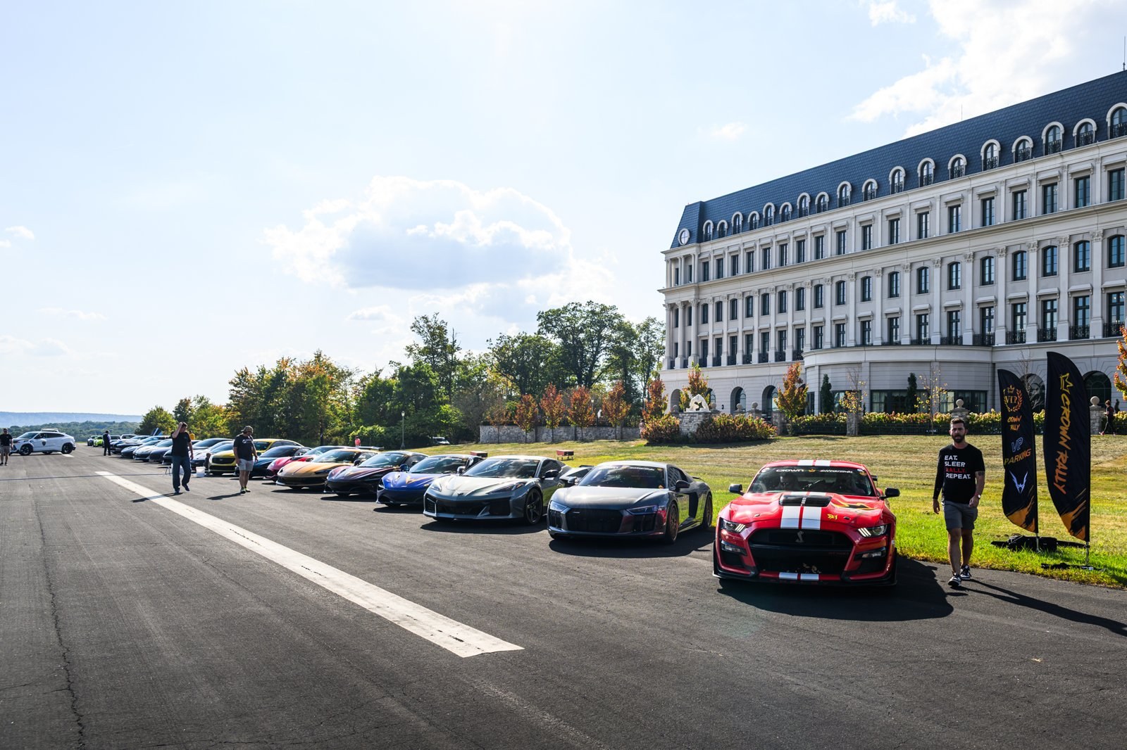 Line of exotic cars parked at a hotel for Crown Rally East 2025 check-in